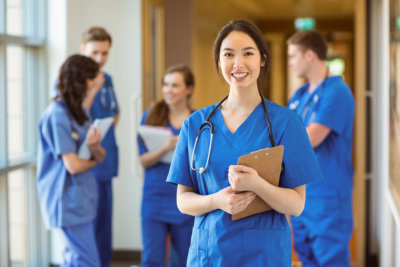 a nurse smiling with other nurses at the background